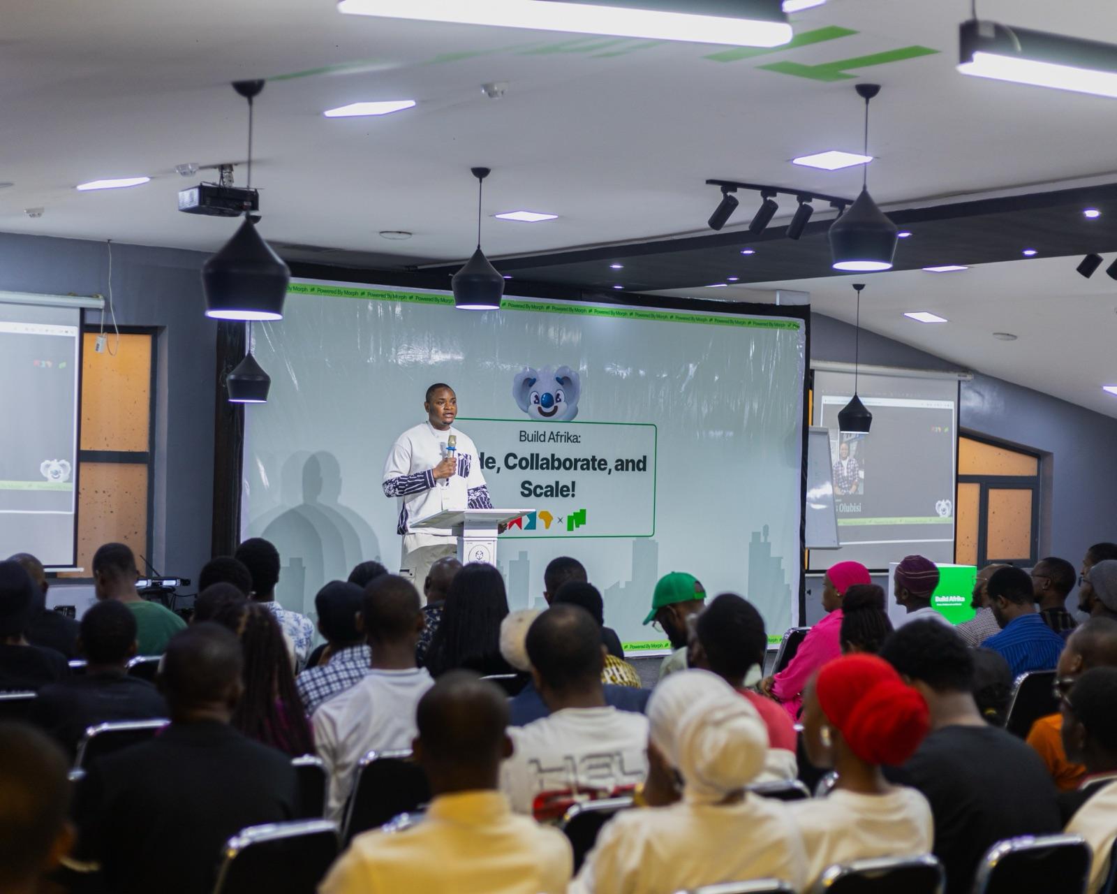 Idris speaking at a lectern at Build Afrika, to a room of developers